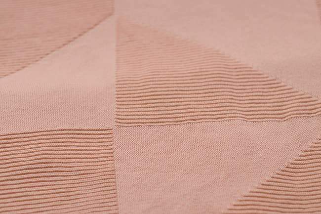 close up of geo panel pattern on peach blanket made in the USA.