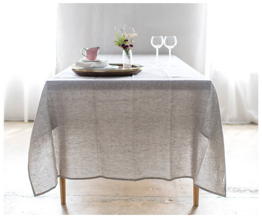Oatmeal Linen Tablecloth draped over a wooden table