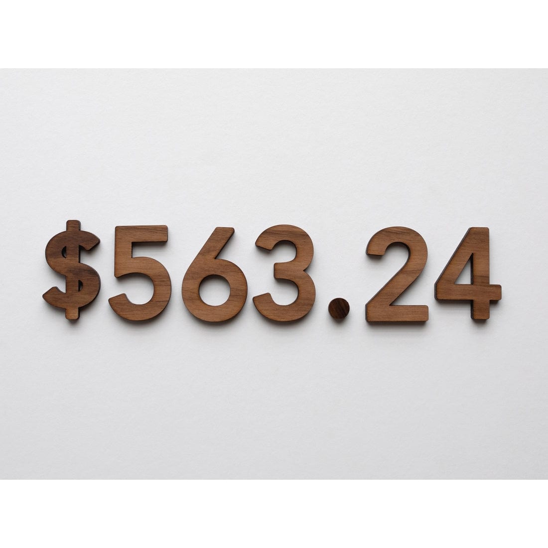 $563.24 displayed in walnut wooden numeral set