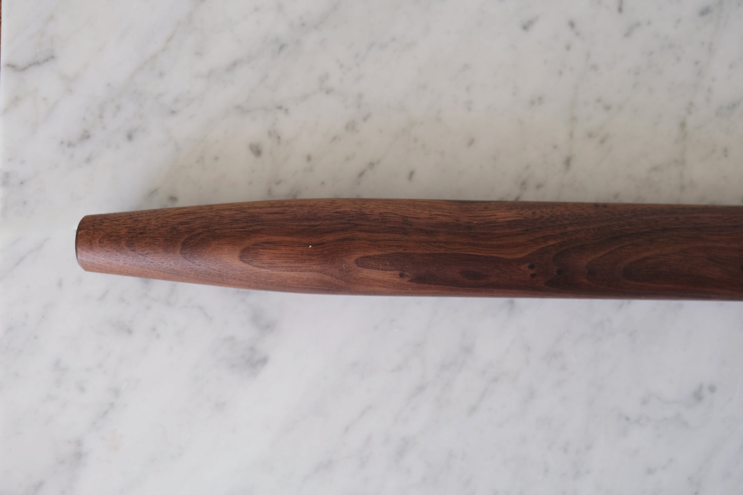 close up view of walnut rolling pin