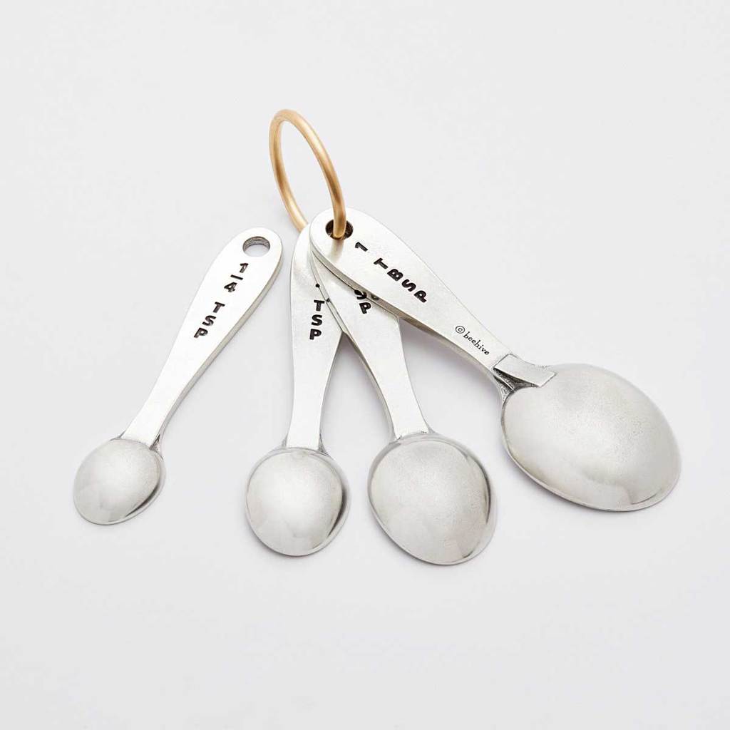 Pewter measuring spoons upside down to show the engraved measurements