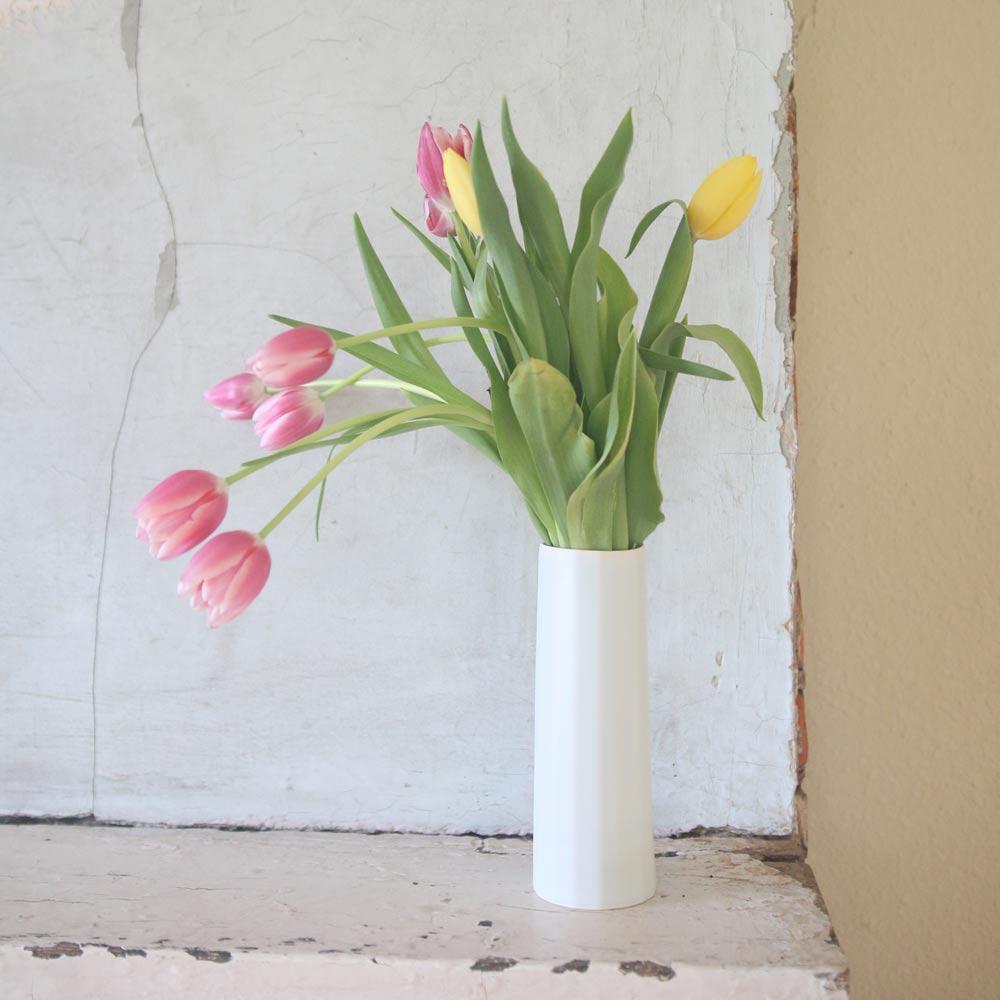 handmade flower vase in white holding tulips