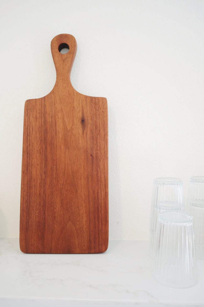 cherry serving board leaned against a wall