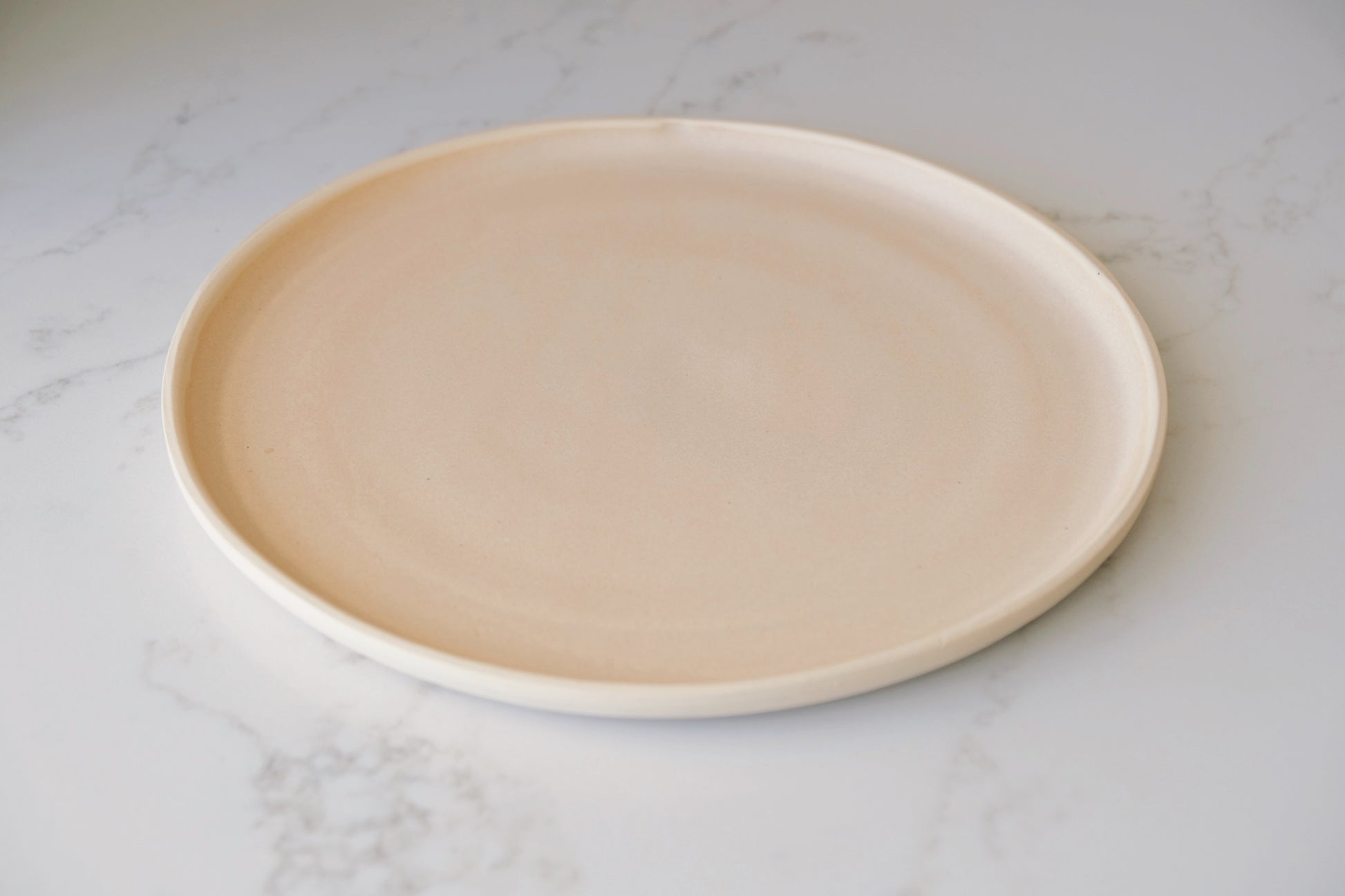 side view of handmade dinner plate in coral