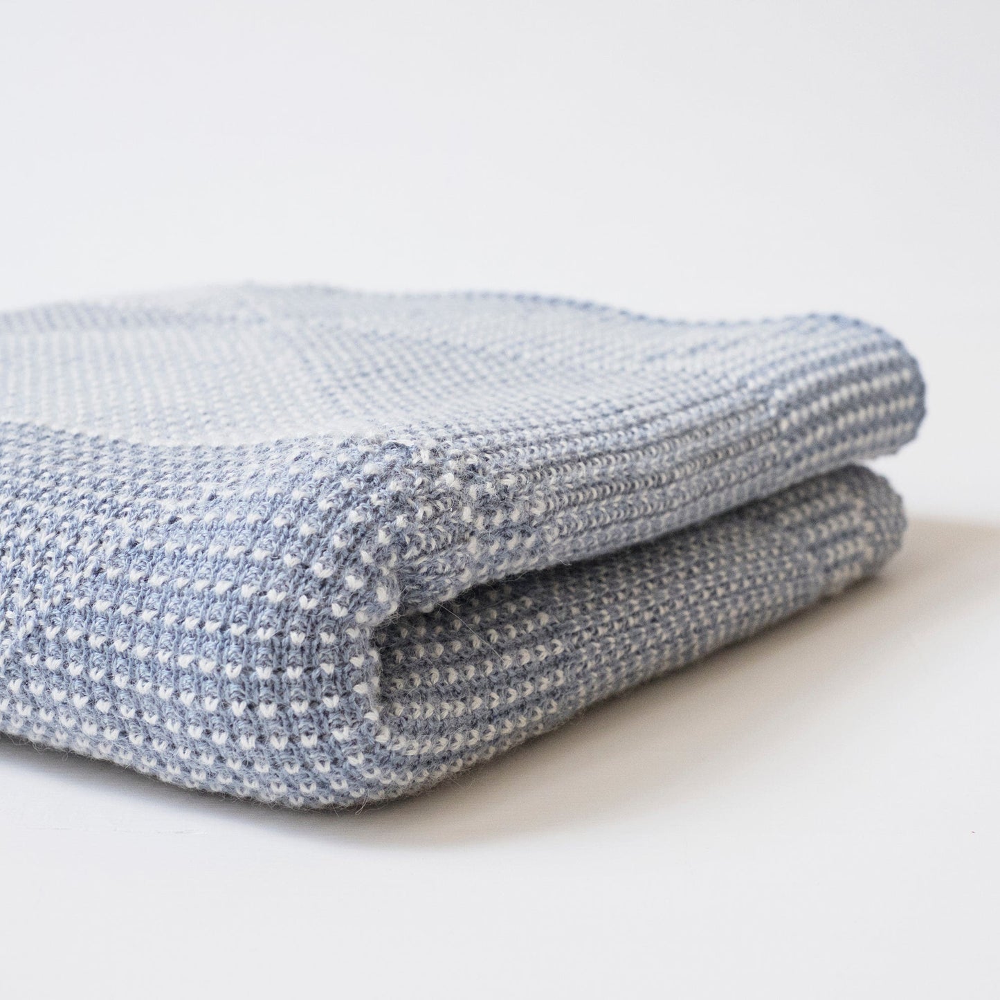 Folded organic cotton baby blanket colored in indigo