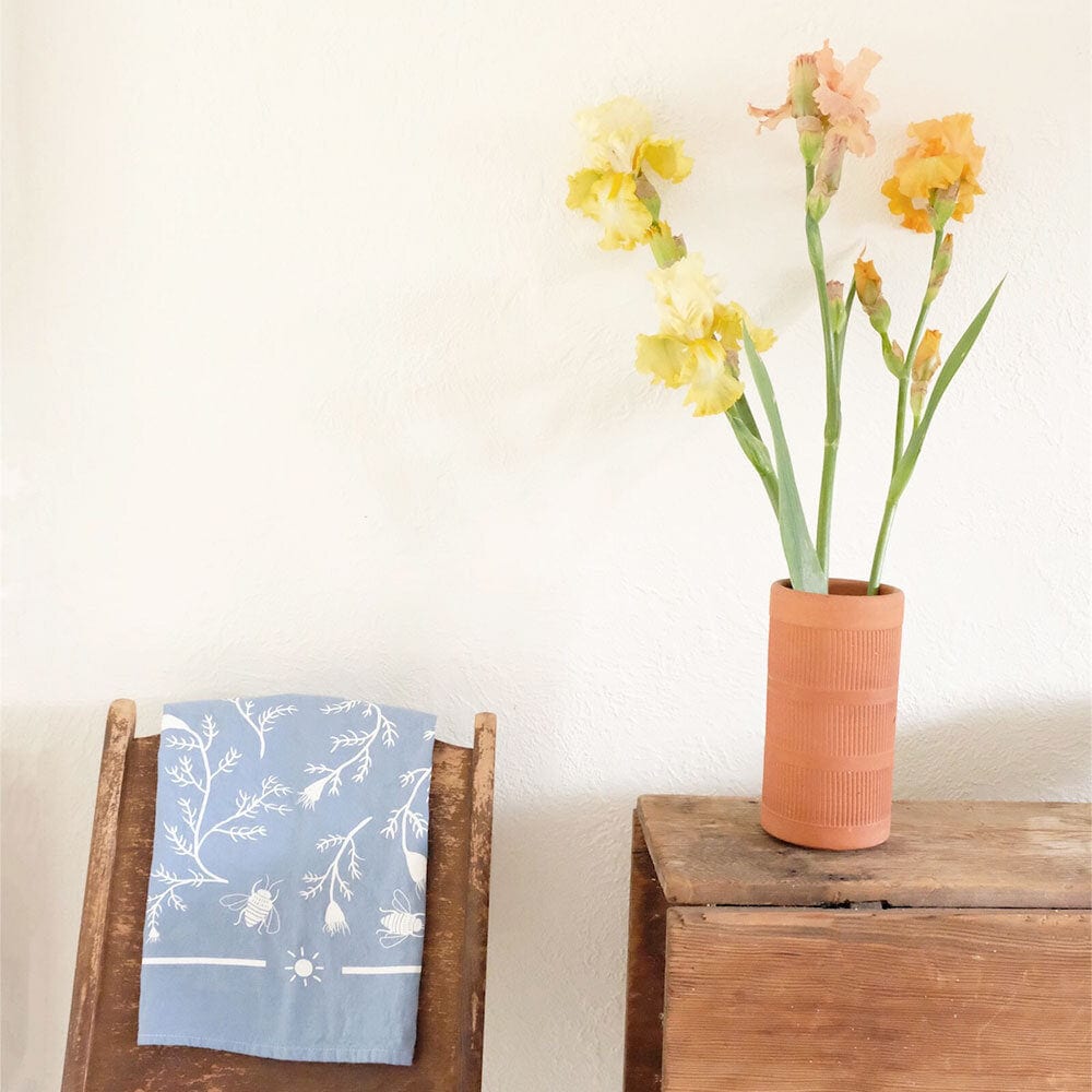 folded thistle tea towel hanging on a wooden chair