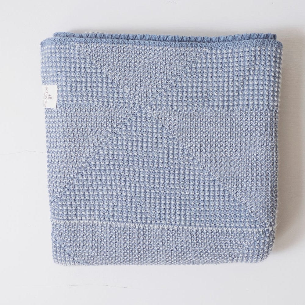 Organic Cotton Baby Blanket colored Indigo folded on a surface to show triangular pattern