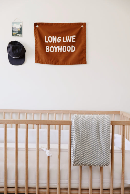 herringbone baby blanket hanging on a crib