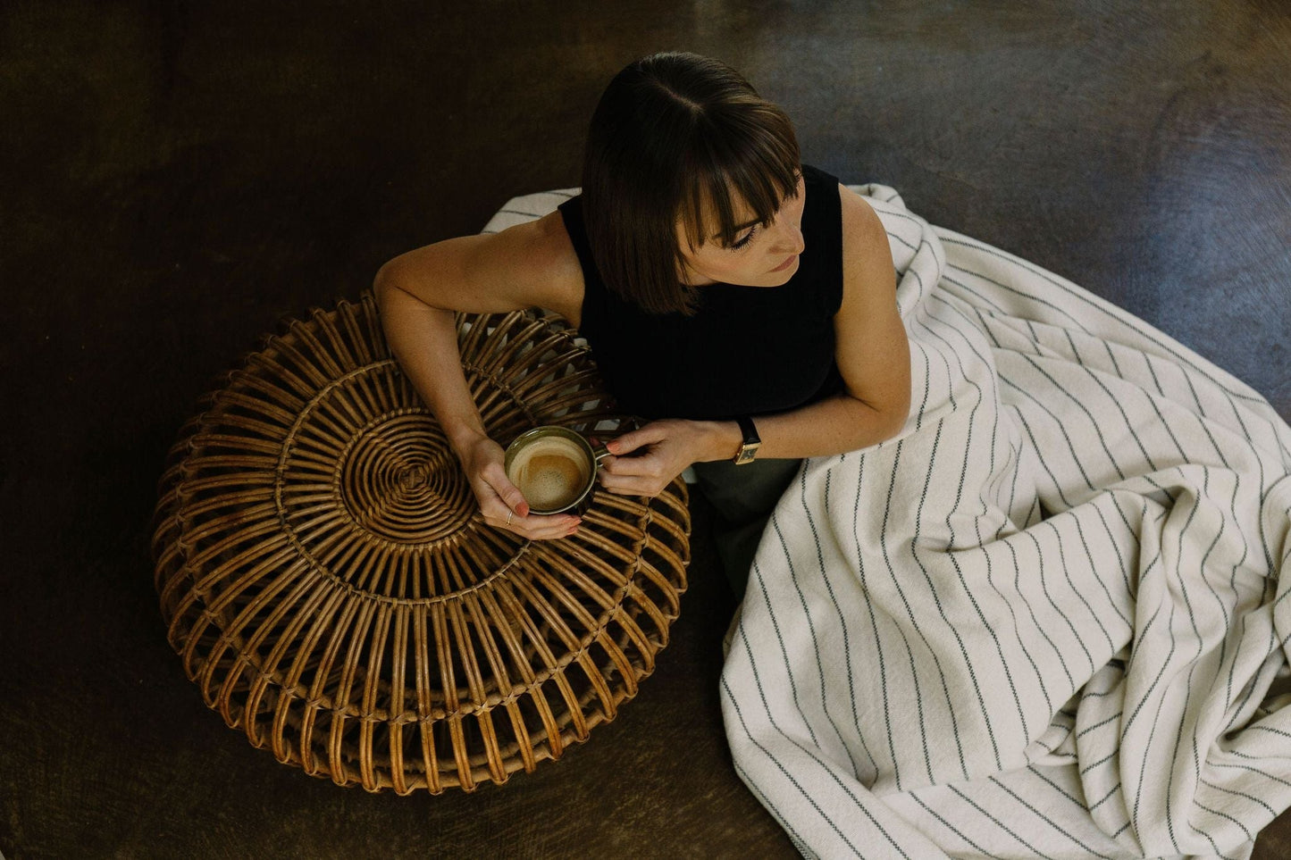 Midnight Blue Pinstripe Throw Blanket covering a woman drinking a coffee. 