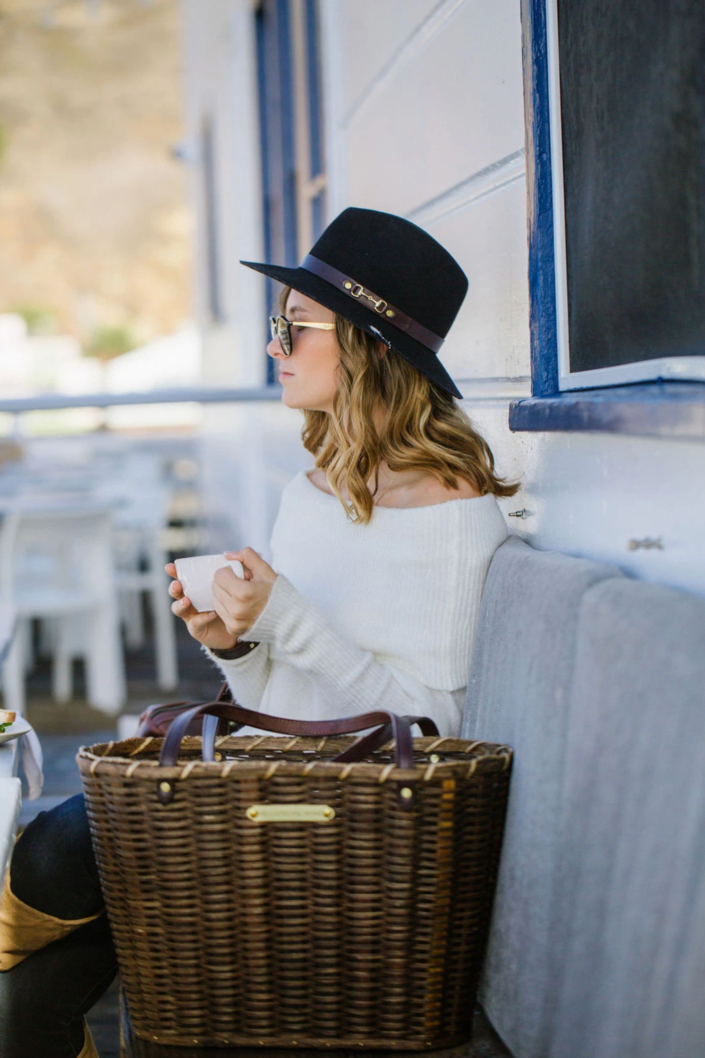 Woman drinking coffee with market basket beside her