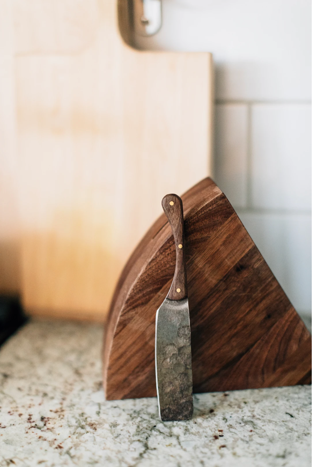 Handcrafted cheese block with hand forged stainless steel knife on a kitchen countertop