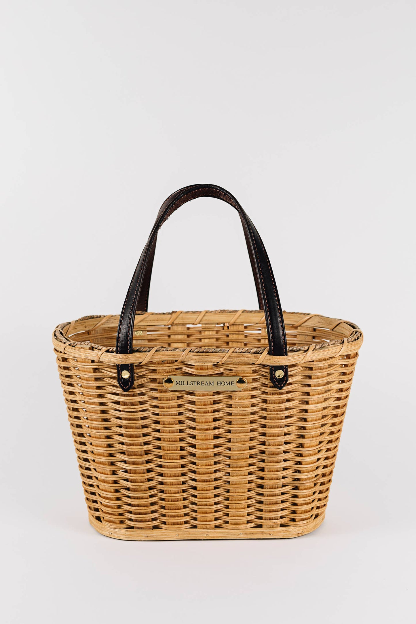 handwoven light colored market basket with leather handles. 