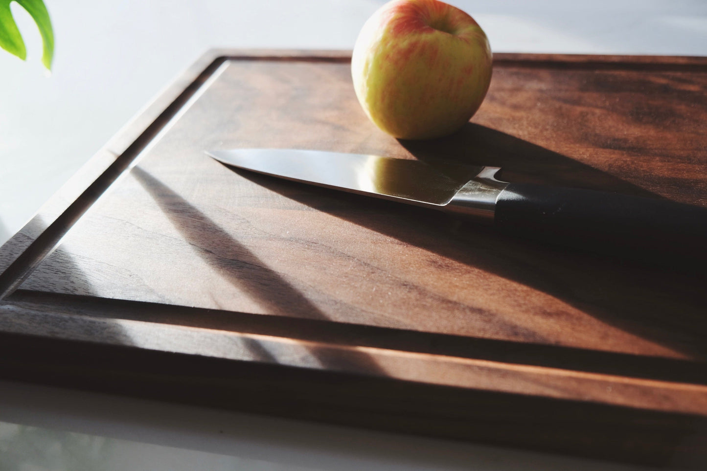 black walnut cutting board with an apple on top