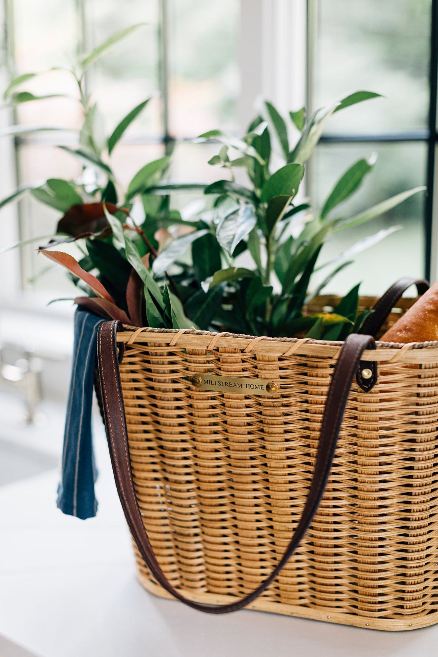 Handwoven Light market basket with leather handles with plants and bread inside