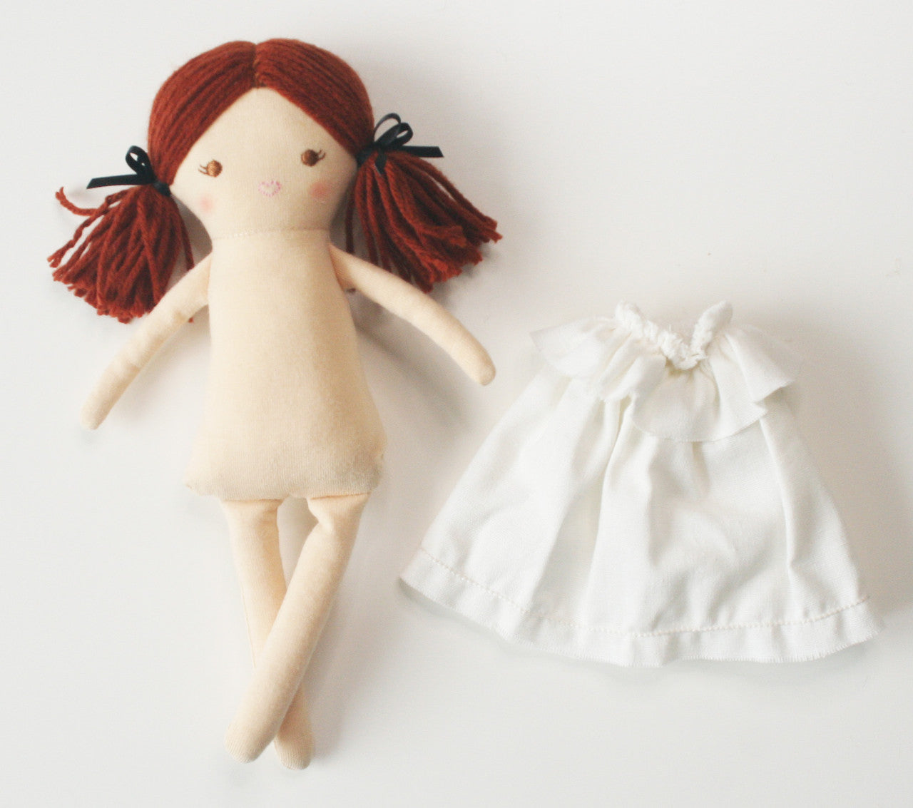 cloth doll with a dress beside it
